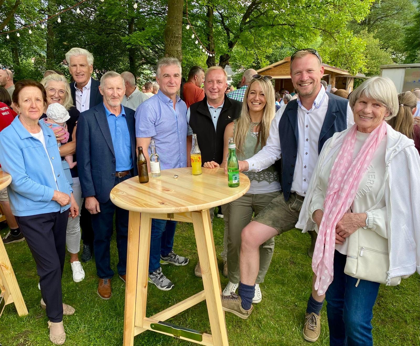 Gruppe von Gästen am Stehtisch im Park bei einem Fest