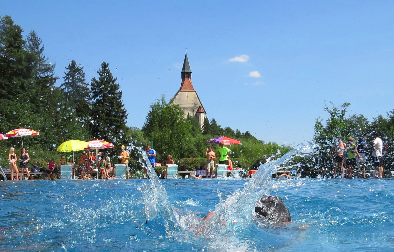 Sommertag im Freibad mit der St. Wolfgangskirche im Hintergrund