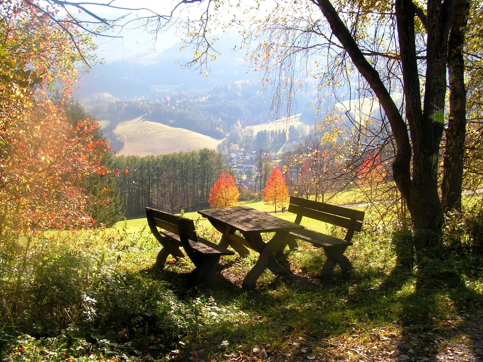 Herbstlicher Rastplatz mit Holzbänken und Blick ins Tal auf Kirchberg am Wechsel